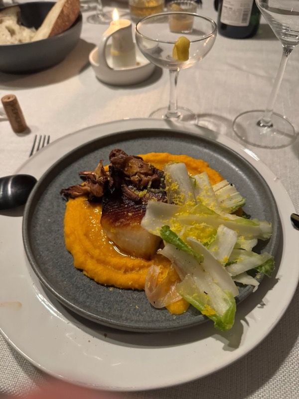 Miso black cod on a butternut squash purée with endive salad and shaved cured egg yolks